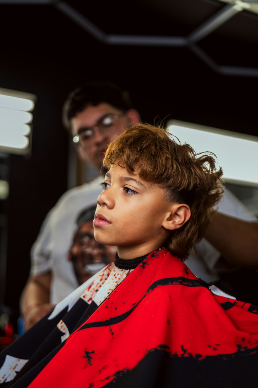 Young boy with a fresh cut in a barber cape